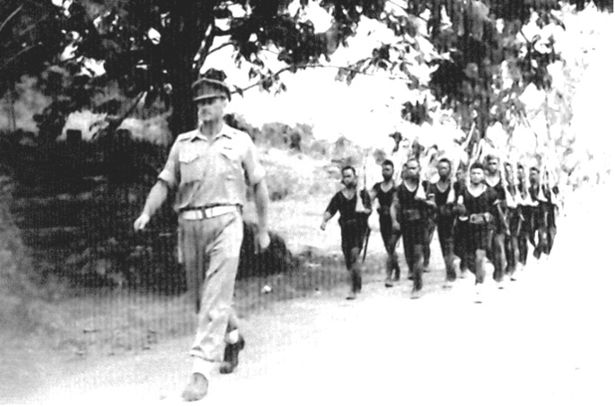 District Officer FNW Shand leads a detachment of New Guinea police to hoist the Australian flag – Kavieng, 1945